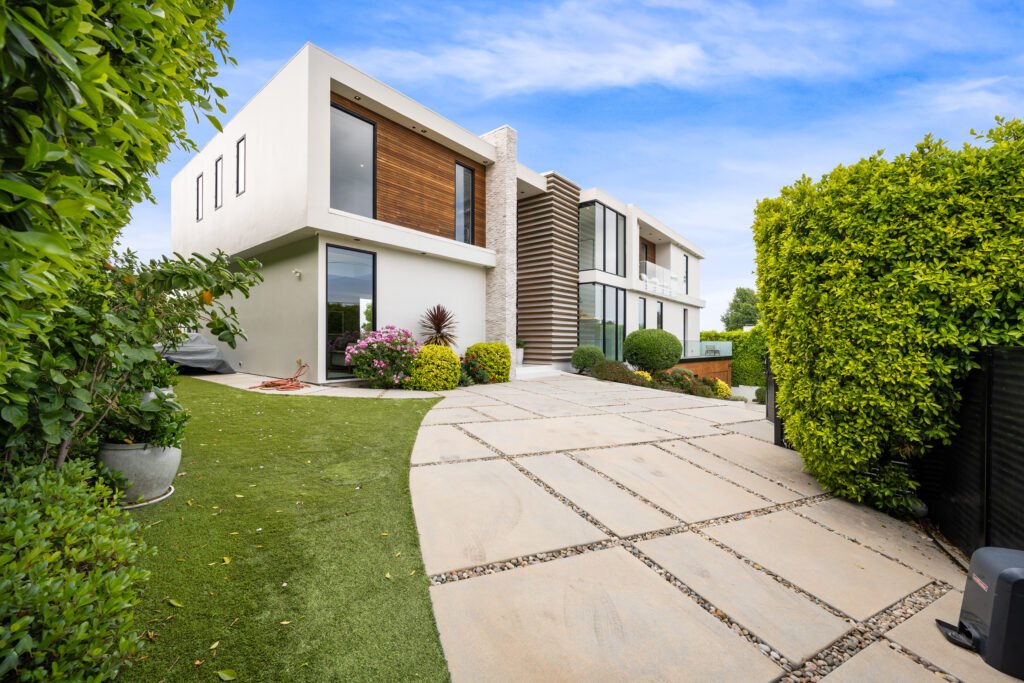 A Driveway of a contemporary house with a garden area